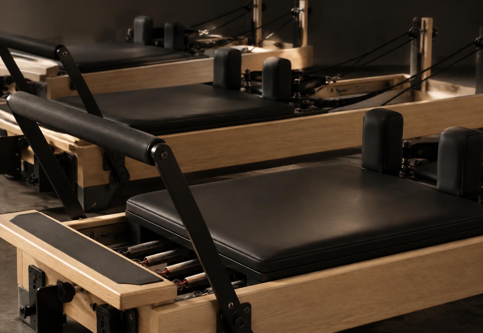 Close-up of a black and oak Reformer carriage, footbar and springs; illustrative equipment photography